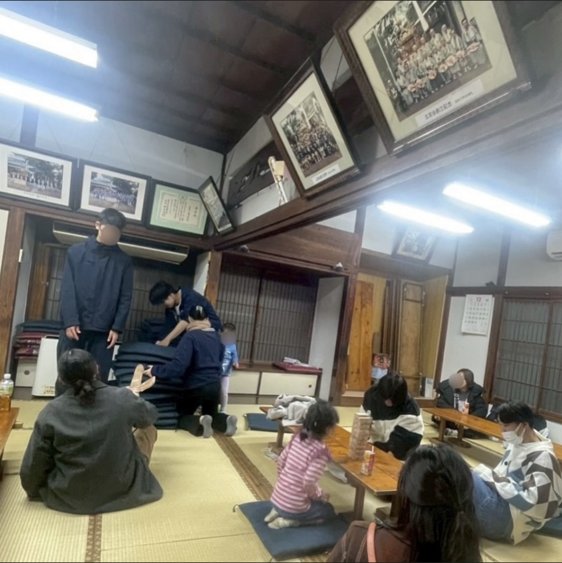畳の集会所で、子どもたちとスタッフが遊んだりテーブルを囲んだりするようす